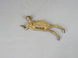 a gold bird that is sitting on a white surface