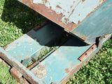 a rusted metal box sitting in the grass