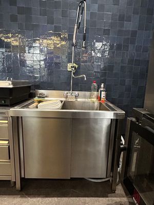 un évier en acier inoxydable au milieu d'une cuisine