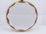 a close up of a gold plated coin purse on a white surface