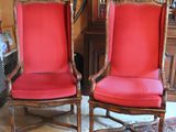 two red chairs in a room with a rug on the floor