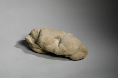 une petite sculpture représentant un cerveau posée sur une surface grise