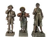 trois statues représentant des hommes, toutes coiffées d'un chapeau
