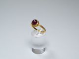 an image of a gold ring with a red stone in it