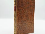 a brown book with gold trim and a red cover
