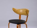 une image représentant une chaise en bois avec une assise noire sur fond blanc
