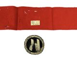 a red belt with a black and white emblem on it