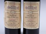 two bottles of red wine sitting next to each other on a table