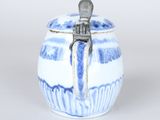 a small blue and white jar with a spoon in it