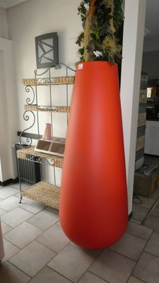 a large vase with a plant in it on a tiled floor