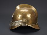 an antique brass helmet on a black background