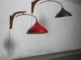 two red and black lamps hanging on a wall next to a wooden floor