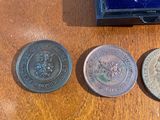 three coins sitting on a table next to a blue box