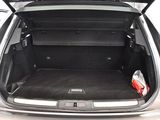 the back of a silver car with its trunk open and luggage in the trunk