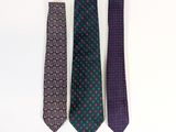 three ties are lined up in a row on a white surface