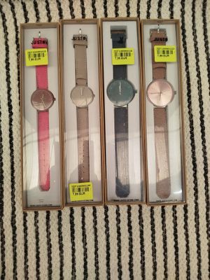 trois montres se trouvent dans une boîte posée sur une surface rayée