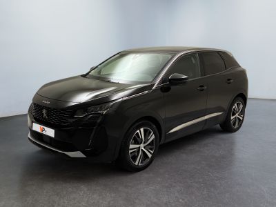 La voiture noire est garée dans une pièce dont le mur est bleu clair.