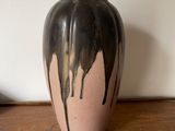 un vase noir et blanc posé sur une table en bois