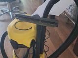 yellow vacuum cleaner on the floor in a room with chairs and a table