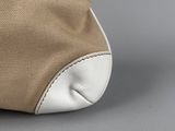 beige and white canvas and leather tote bag on grey background