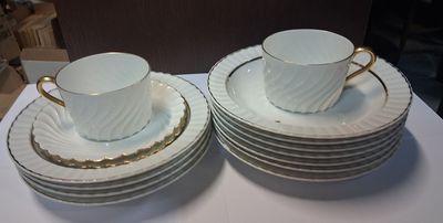 two cups and a saucer on top of a stack of plates