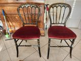 une paire de chaises aux assises recouvertes de velours rouge, placées devant une commode