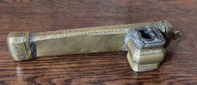 a small brass object on a wooden table