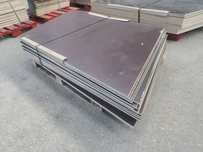 une pile de tôles d'acier posée sur des palettes dans un entrepôt