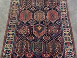 un tapis persan ancien à motifs géométriques sur fond gris