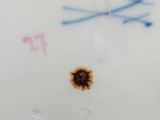a close up of a plate with a sunflower painted on it