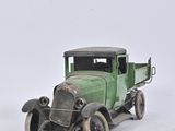 a green toy truck sitting on a white surface