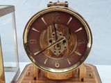 a clock that is sitting on top of a wooden stand