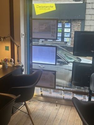 a desk with two chairs in front of a window