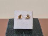 a pair of gold earrings on a marble block