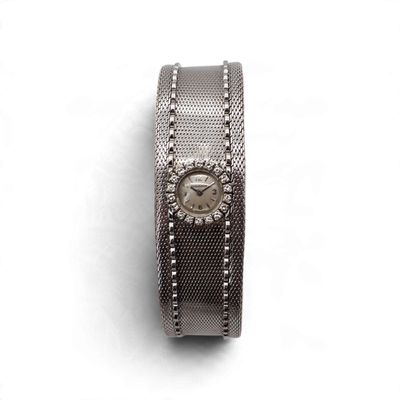 une image d'un gros plan d'une montre-bracelet sur une surface blanche
