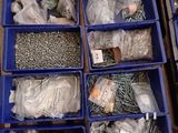 a lot of different types of screws and nuts in blue bins