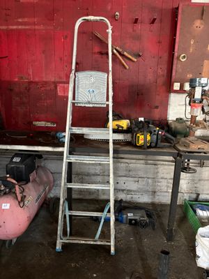 une photo d'un lieu de travail avec des outils et une échelle