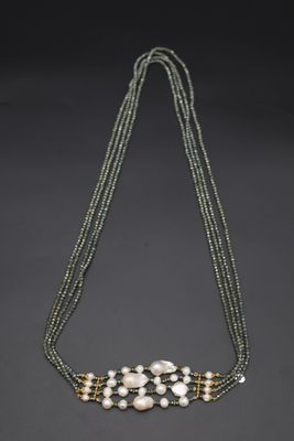 un gros plan d'un collier de perles sur fond noir