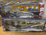 deux petits trains en plastique dans des sachets, posés sur une table