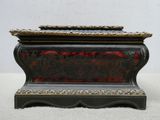 une boîte noire et dorée ornée d'un motif rouge