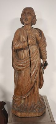 a wooden statue of a woman holding a bag