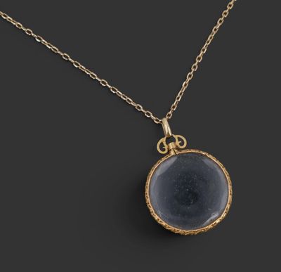 un collier plaqué or avec un pendentif en verre bleu monté sur une chaîne