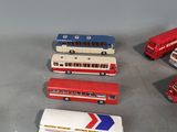 several toy buses are lined up in a row on a table