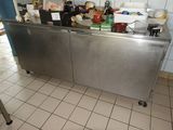 un plan de travail en inox sur lequel sont posés tout un tas d'aliments
