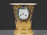 un vase doré et bleu sur lequel est représentée une horloge
