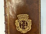 un vieux livre orné d'un emblème doré, posé sur une table