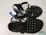 two pairs of black sandals with studded straps on a white surface