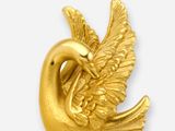 a gold plated bird brooch on a white background