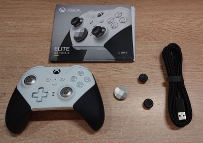une manette blanche posée sur une table à côté d'un boîtier noir et blanc