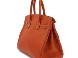 a brown leather handbag on a white background